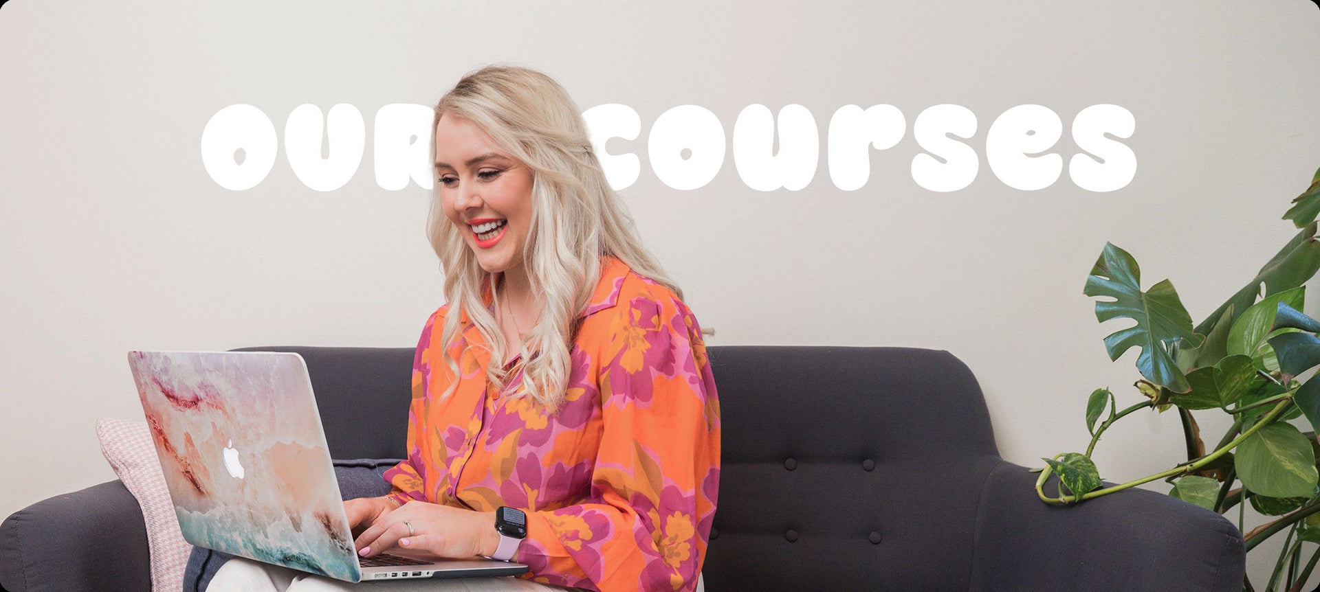 Flic from Your Fan Club smiling while working on her laptop, with ‘Our Courses’ text in the background.